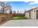 Backyard view with privacy fence, putting green, and detached garage with concrete pad at 1996 S Dexter St, Denver, CO 80222