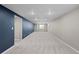 Wide open finished basement space with blue accent wall and neutral carpeting at 1996 S Dexter St, Denver, CO 80222