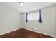 Neutral bedroom with hardwood floors, window with blinds, and minimalist decor at 1996 S Dexter St, Denver, CO 80222