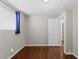 Neutral bedroom with hardwood floors, large window, and a door leading to additional rooms at 1996 S Dexter St, Denver, CO 80222