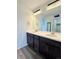 Bathroom featuring dual sinks, modern lighting, and a spacious vanity at 3029 Merlin Dr, Brighton, CO 80601