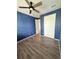 Cozy bedroom featuring stylish blue walls, wood floors, and a ceiling fan at 3029 Merlin Dr, Brighton, CO 80601