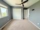 Bedroom features a ceiling fan, neutral carpet, and a closet with sliding doors at 3029 Merlin Dr, Brighton, CO 80601