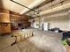 Spacious garage with tall ceilings, shelving, and a convenient roll-up door for easy access and storage at 3029 Merlin Dr, Brighton, CO 80601