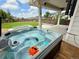 A bubbly hot tub sits on a wooden deck overlooking the lawn, with neighborhood views at 3029 Merlin Dr, Brighton, CO 80601