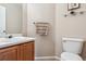 Neat half-bathroom with wood vanity, round sink, toilet, and glass shelf at 10825 Mount Antero Way, Parker, CO 80138