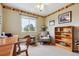 Bedroom with large window, ceiling fan, wood desk, and an arm chair with side table at 10825 Mount Antero Way, Parker, CO 80138