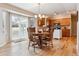 Bright eat-in kitchen with wooden dining set, hardwood floors, and sliding glass door to the patio at 10825 Mount Antero Way, Parker, CO 80138