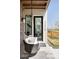 Inviting front porch featuring a swing, textured wall and modern exterior lights at 21418 E 61St Dr, Aurora, CO 80019