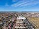 Expansive aerial view of a suburban community displaying homes, commercial areas, mountains and city skyline at 8985 E 29Th Pl, Denver, CO 80238