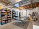Finished basement area with a ping pong table and open ceiling, perfect for recreational activities and storage at 8985 E 29Th Pl, Denver, CO 80238