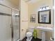 Bright bathroom featuring a glass-enclosed shower, pedestal sink, decorative mirror, and black and white accent tiles at 8985 E 29Th Pl, Denver, CO 80238