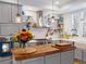 Charming kitchen island with butcher block countertop, pendant lights, and stainless steel range hood at 8985 E 29Th Pl, Denver, CO 80238