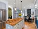 Modern kitchen with a butcher block island and a dining table, creating a comfortable and functional space at 8985 E 29Th Pl, Denver, CO 80238