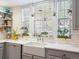 Bright farmhouse sink with plants, subway tile backsplash, and gray cabinets, creating a cozy atmosphere at 8985 E 29Th Pl, Denver, CO 80238