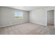 Bright bedroom with plush carpet, a large window overlooking the green space, and a walk-in closet at 7307 Dolores Ave, Frederick, CO 80530