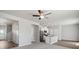 Spacious living area featuring modern ceiling fan, kitchen with granite countertops, and view of the front entrance at 7307 Dolores Ave, Frederick, CO 80530