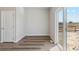 Bright, airy living room with wood-look flooring and sliding glass doors leading to a fenced backyard at 7307 Dolores Ave, Frederick, CO 80530