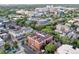 Expansive aerial view of a red brick apartment building surrounded by lush greenery and urban architecture at 836 E 17Th Ave # 1A, Denver, CO 80218