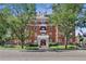 Elegant brick building with classic architectural details and mature trees at 836 E 17Th Ave # 1A, Denver, CO 80218