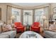 Bright living room with a bay window, two red chairs, and comfortable gray sofas at 836 E 17Th Ave # 1A, Denver, CO 80218