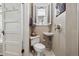 A modern powder room with pedestal sink, floating toilet, and shuttered window at 836 E 17Th Ave # 1A, Denver, CO 80218