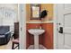 Stylish powder room with decorative mirror, orange wainscoting, pedestal sink, and neutral colored upper walls at 836 E 17Th Ave # 1A, Denver, CO 80218
