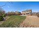Back of house with a grass yard and concrete patio, next to a gravel section and wood fence at 6786 Halifax Ave, Castle Rock, CO 80104