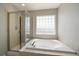 Bright bathroom featuring a glass-enclosed shower and a luxurious soaking tub at 6786 Halifax Ave, Castle Rock, CO 80104