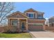 Inviting two-story home featuring a two-car garage, stone accents, and a well-manicured lawn at 6786 Halifax Ave, Castle Rock, CO 80104