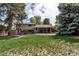 Expansive backyard with a well-maintained lawn, patio area, and mature trees offering shade at 6211 S Garfield Dr, Centennial, CO 80121