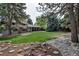 Spacious backyard with lush lawn, mature trees, and a rock garden at 6211 S Garfield Dr, Centennial, CO 80121