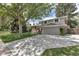 Exterior view of the house with large driveway and mature trees providing ample shade at 6211 S Garfield Dr, Centennial, CO 80121