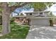 Exterior view of the home featuring a well-manicured front yard and mature shade trees at 6211 S Garfield Dr, Centennial, CO 80121