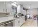 Modern kitchen with stainless steel appliances, white cabinetry, and a view of the adjacent living space at 6211 S Garfield Dr, Centennial, CO 80121