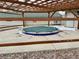 Exterior view of a hot tub covered by a tarp and surrounded by a wooden pergola and landscaping at 7292 S Blackhawk St # 2-306, Englewood, CO 80112