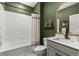 Stylish bathroom featuring a tub/shower combo, a modern vanity, and a classic green color scheme at 2040 Rosette Pl, Castle Rock, CO 80104