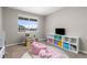 Bright bedroom with a large window, play area, and neutral decor at 2040 Rosette Pl, Castle Rock, CO 80104
