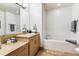 Bathroom with vanity, tile floor, and a tub with white tile surround at 2958 Syracuse St # 214, Denver, CO 80238