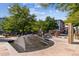 A community park with landscaping, pedestrian walkways, water features, and a modern building at 2958 Syracuse St # 214, Denver, CO 80238