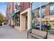 A daytime exterior shot of a local retail district with inviting sidewalk seating and storefronts at 2958 Syracuse St # 214, Denver, CO 80238