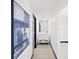 Hallway with a tiled floor, blue accent and leading to a walk-in closet and a bathroom with a vanity at 4842 Steele St, Denver, CO 80216