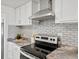 Kitchen featuring stainless steel oven and range with decorative tile backsplash at 4842 Steele St, Denver, CO 80216