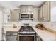 Kitchen showcasing stainless steel microwave, stove, and gray cabinets with modern hardware at 1308 W 102Nd Ave, Northglenn, CO 80260