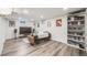 Well-lit living room with hardwood floors, large TV and a bookshelf provides a comfortable entertainment space at 1308 W 102Nd Ave, Northglenn, CO 80260