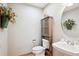 Powder room with pedestal sink, toilet and decorative storage at 1060 Cottonwood Cir, Golden, CO 80401