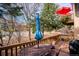 Relaxing deck with table, chairs, and umbrella; views of trees and street at 1060 Cottonwood Cir, Golden, CO 80401