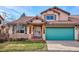 Tan two-story home with a teal garage door and landscaping at 1060 Cottonwood Cir, Golden, CO 80401