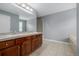 Neutral bathroom featuring a double sink vanity, walk-in shower, and tiled floors at 9461 Elmhurst Ln # C, Highlands Ranch, CO 80129