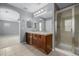 Bathroom features double sinks, a shower, vanity, and neutral tiling with an open doorway at 9461 Elmhurst Ln # C, Highlands Ranch, CO 80129